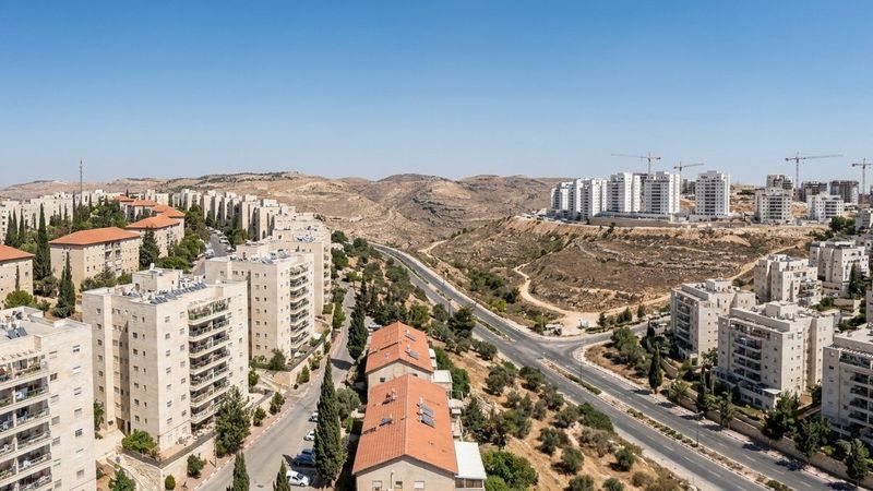 Panorama over the ridges of Ramat Beit Shemesh with older stone blocks, new towers and cranes (illustration)
